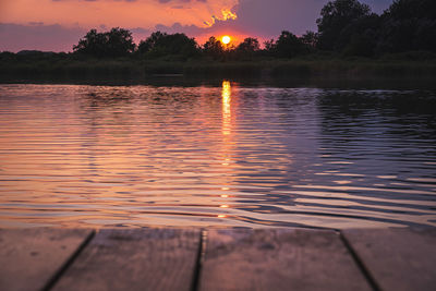 Scenic view of lake against sky at sunset