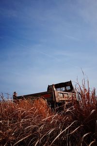 Abandoned house on field against sky