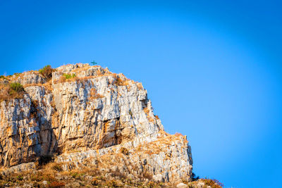 Low angle view of rock formation against blue sky