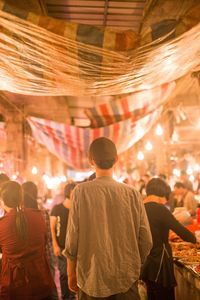 People shopping at illuminated street market