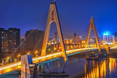 Suspension bridge over river at night