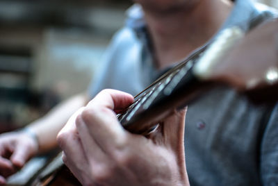 Midsection of man playing guitar