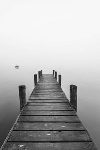 Wooden pier over lake against sky