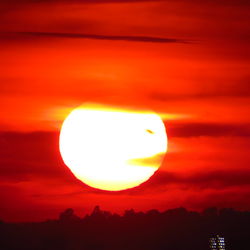 Silhouette landscape against orange sky