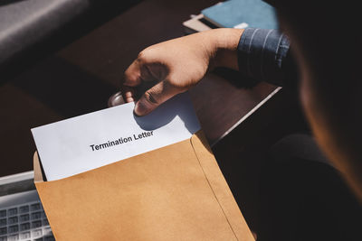 High angle view of woman holding text on paper