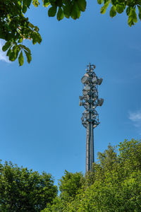 Low angle view of communications tower against blue sky