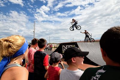 People on bicycle against sky