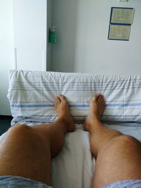 Low section of woman lying on bed at home