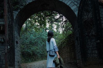 Rear view of woman standing by tree