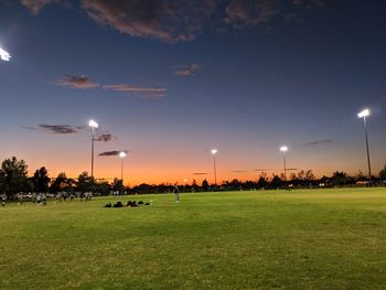 Soccer field against blue sky during sunset