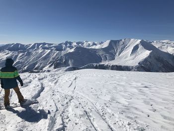 Rear view of person on snowcapped mountains against sky