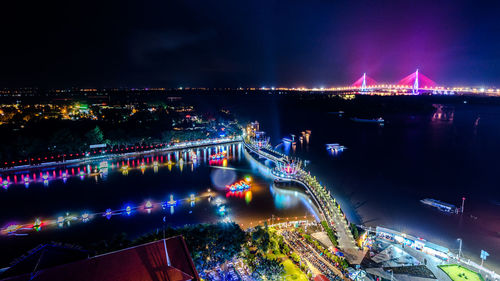 High angle view of illuminated bridge over river in city at night