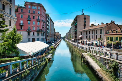 Canal amidst buildings in city against sky