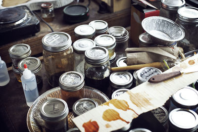 High angle view of jars and containers on workbench in workshop