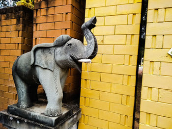 View of elephant statue against brick wall