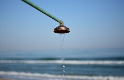 Close-up of water falling on sea against clear sky