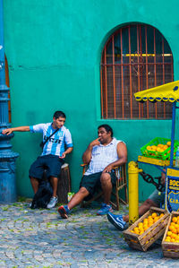 Full length of men sitting at market stall