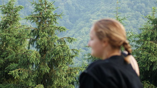 Portrait of woman standing against plants