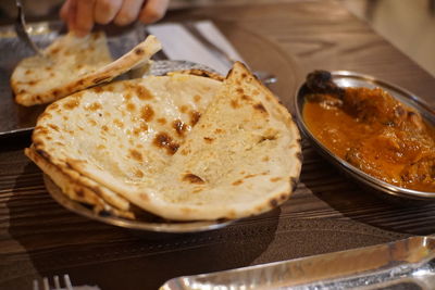 Close-up of hand in plate on table