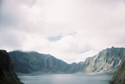 Scenic view of sea and mountains against sky