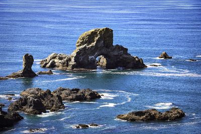 Rock formation on sea shore against sky