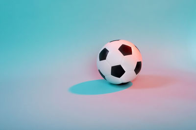 Close-up of soccer ball over colored background