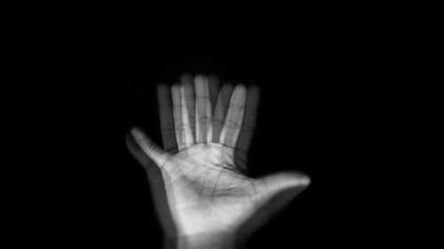 Close-up of human hand against black background