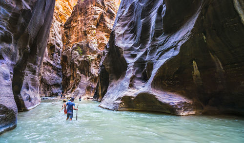 Rear view of man surfing in cave