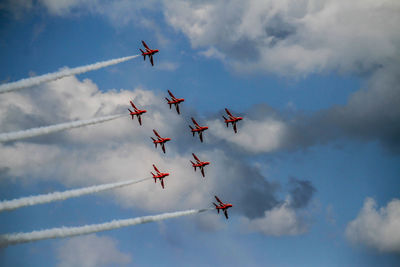 Low angle view of airshow against sky