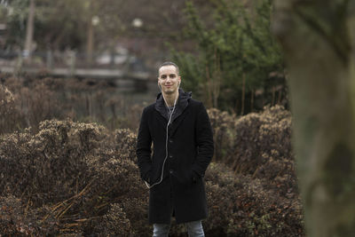 Portrait of young man standing in forest