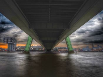 Bridge over river against sky in city