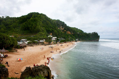 People at beach against sky