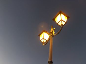Low angle view of illuminated street light against clear sky at night