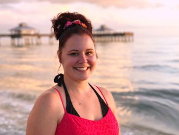 Portrait of young woman standing at beach