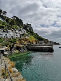 Scenic view of sea by buildings against sky