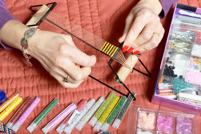 Cropped hands of woman making bracelet