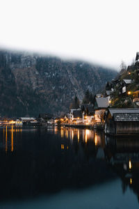 River by illuminated city against clear sky at night