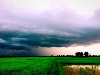 Scenic view of field against dramatic sky