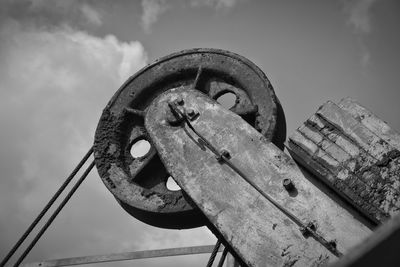 Low angle view of old wheel against sky