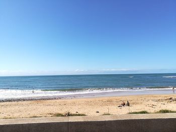 Scenic view of beach against clear blue sky