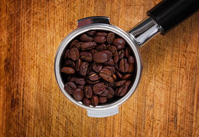 Close-up of coffee beans in portafilter on table