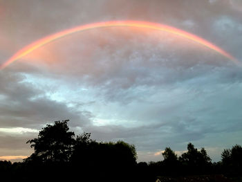 Low angle view of rainbow against sky at sunset