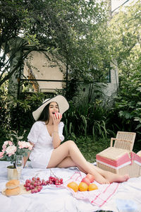 Woman sitting on table against plants