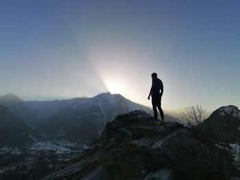 Man standing on snowcapped mountain against sky