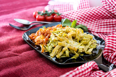 Close-up of pasta and prawns in plate with napkin on table