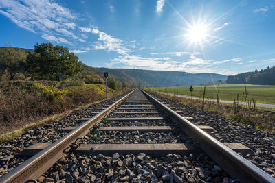 Railroad tracks amidst trees against sky