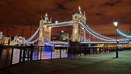 Illuminated suspension bridge over river at night