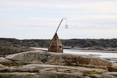 Abandoned building by rocks against sky