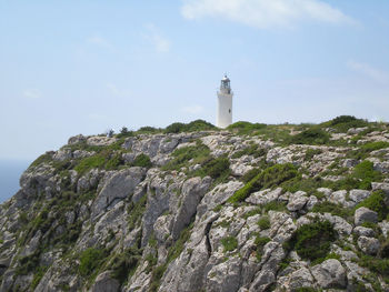 Lighthouse on cliff by sea against sky in formentera island spain 