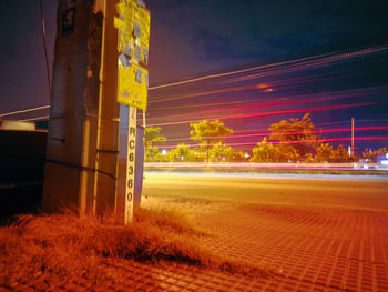 Light trails on road against sky at night